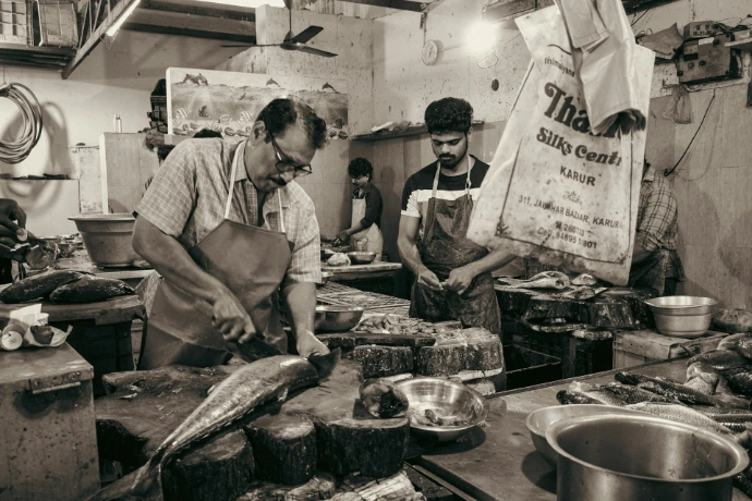 Butchers preparing fish in a market
